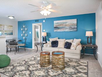 Living Room with Plush Carpet, Ceiling Fan & Blue Accent Wall